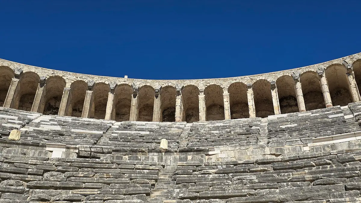 Aspendos'un dik ve yüksek oturma basamakları; ince bir minder ve kapalı ayakkabı burada gerçekten fark yaratıyor.