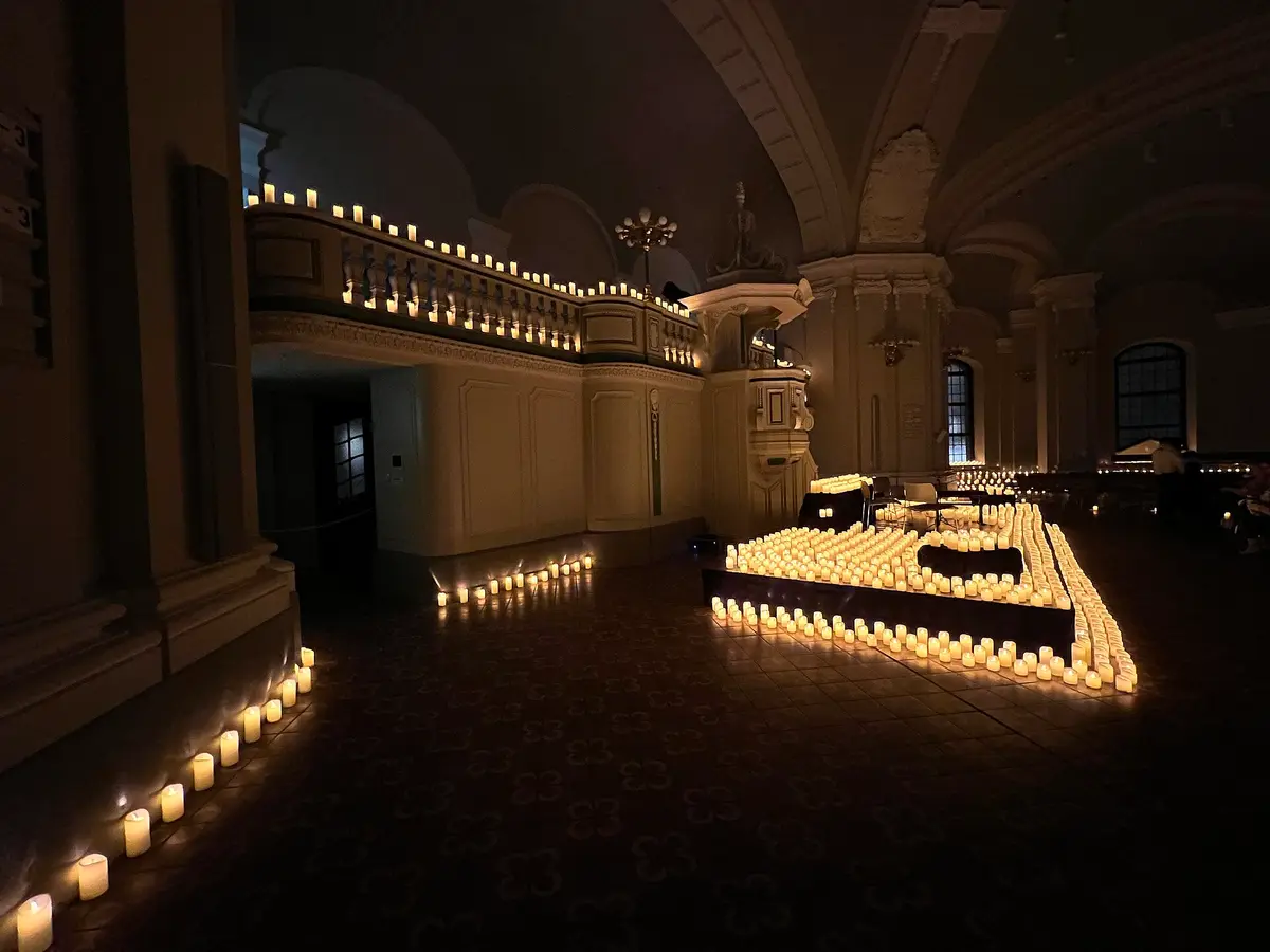 Tarihi bir kilise salonunda mum ışıklarıyla kurulmuş sahne: Candlelight formatının en tanınan görüntülerinden biri.